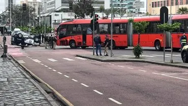 Imagem mostra um acidente com biarticulado e viatura no Centro de Curitiba.