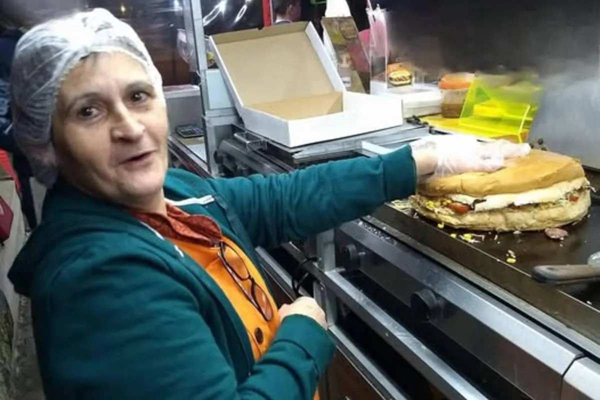 Imagem mostra uma mulher fazendo um lanche gigante