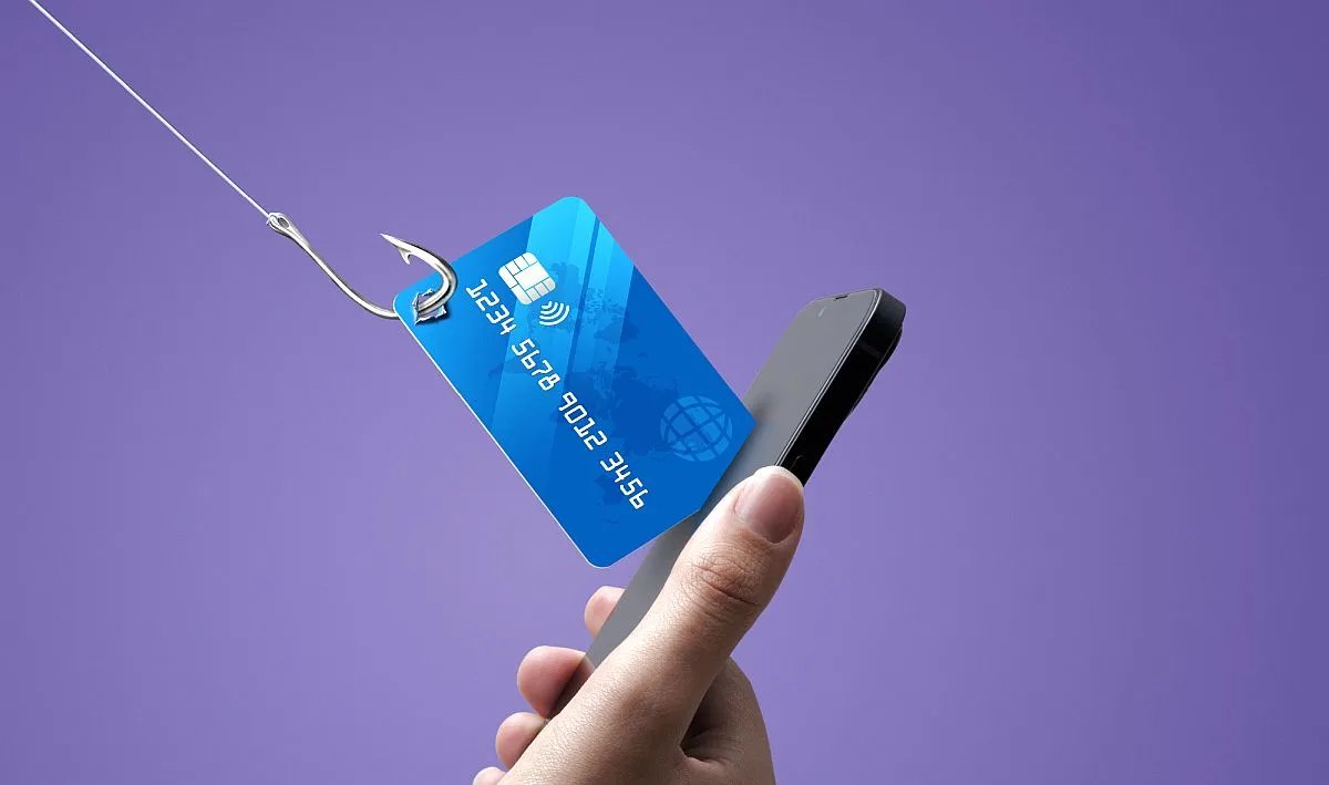imagem ilustrativa mostra um cartão de créditos saindo da tela de um celular, com um anzol pendurado nele