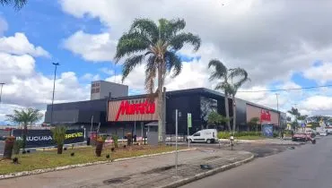 imagem mostra fachada do Muffato do Jardim das Américas. EM primeiro plano um portão para o estacionamento e edifício atras.