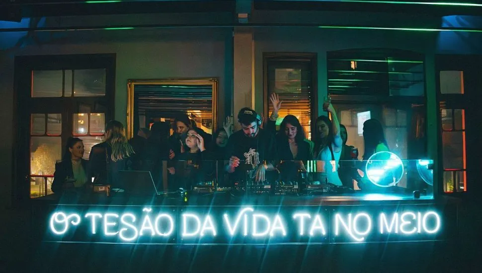 Imagme mostra várias pessoas dentro da casa noturna, com a frase "O tesão da vida está no meio".