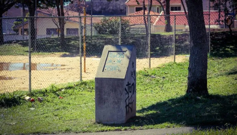 Imagem mostra uma praça em Curitiba que está abandonada e cheia de estragos.