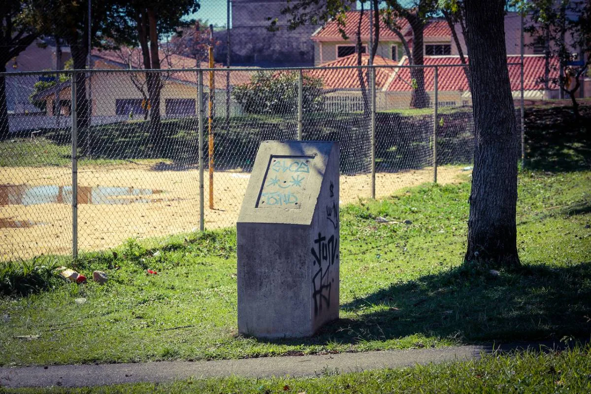 Imagem mostra uma praça em Curitiba que está abandonada e cheia de estragos.