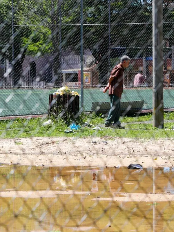 Imagem mostra uma praça em Curitiba que está abandonada e cheia de estragos.