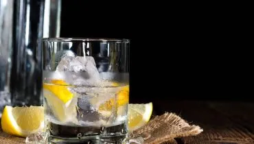 Imagem mostra um drink com um destilado, vodka e limão.