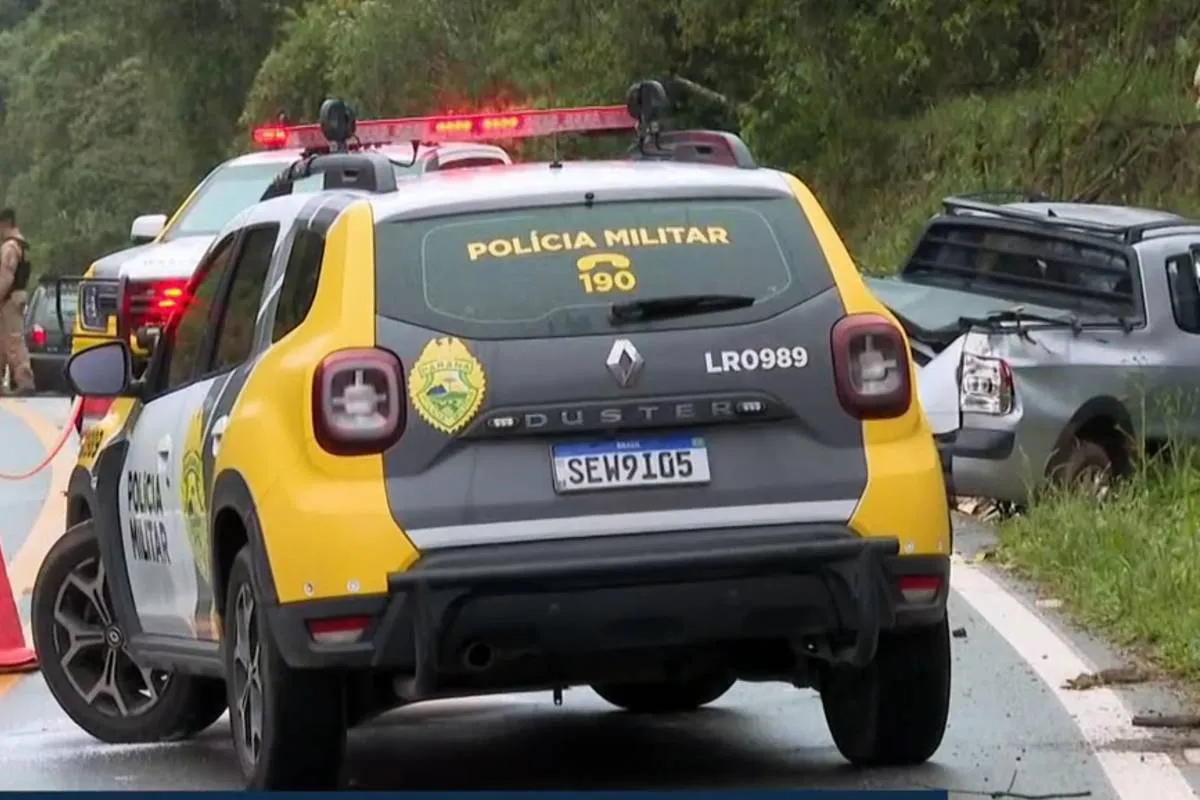 Imagem mostra uma viatura da polícia militar do Paraná e uma Saveiro acidentada ao fundo.