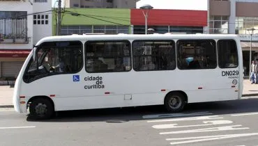 Imagem mostra um micro-ônibus branco estacionado