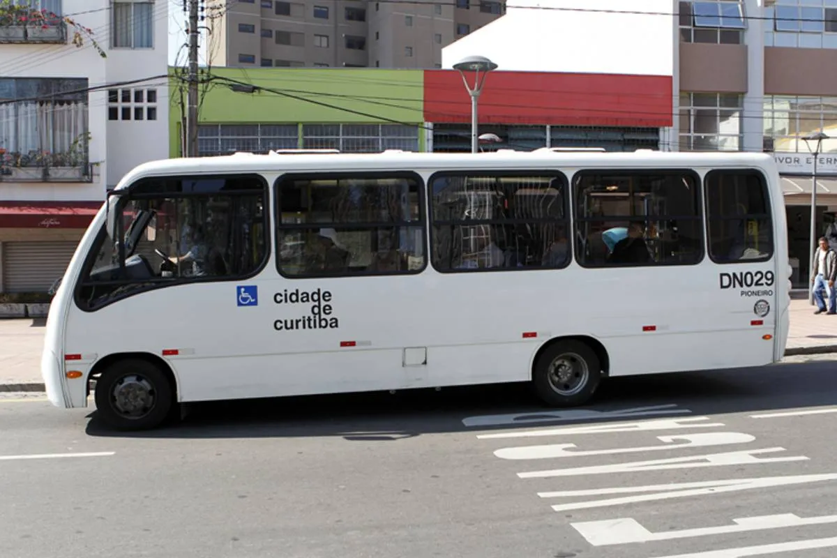 Imagem mostra um micro-ônibus branco estacionado