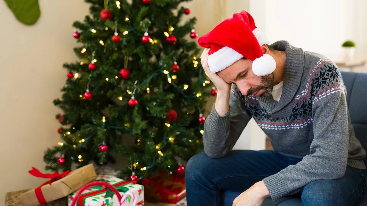 Imagem mostra árvore de Natal e homem triste