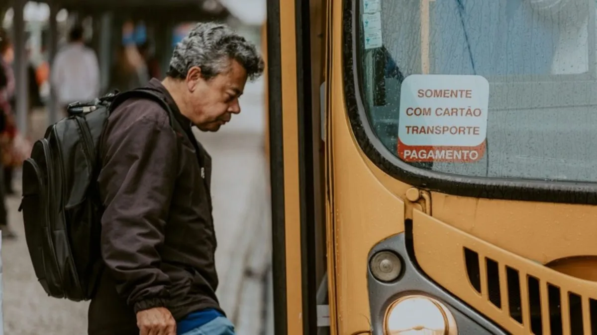 Imagem mostra homem entrando em ônibus, em Curitiba