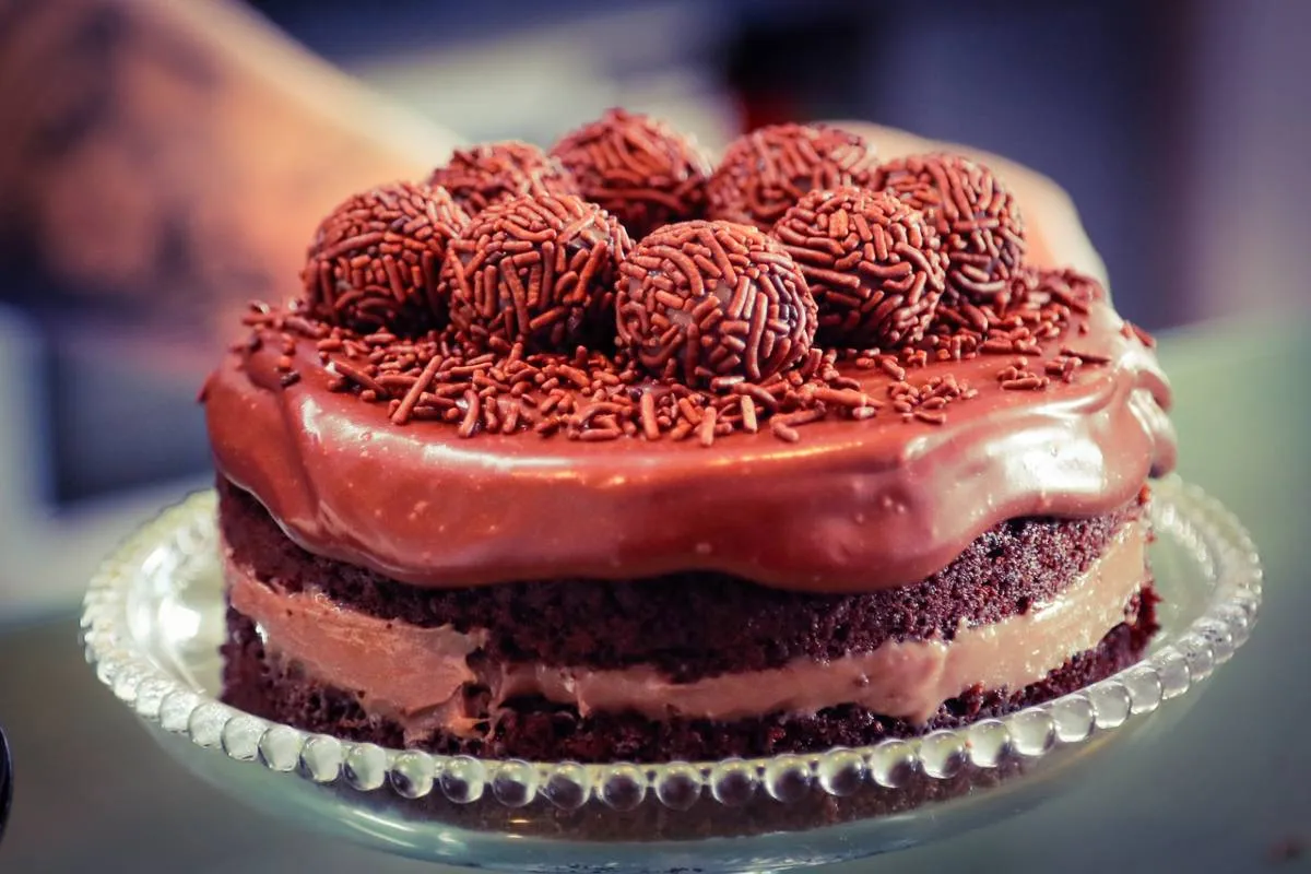 Imagem mostra uma confeiteira fazendo um belo e saboroso bolo.