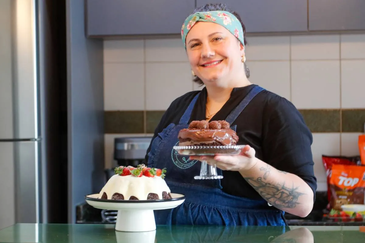 Imagem mostra uma confeiteira fazendo um belo e saboroso bolo.