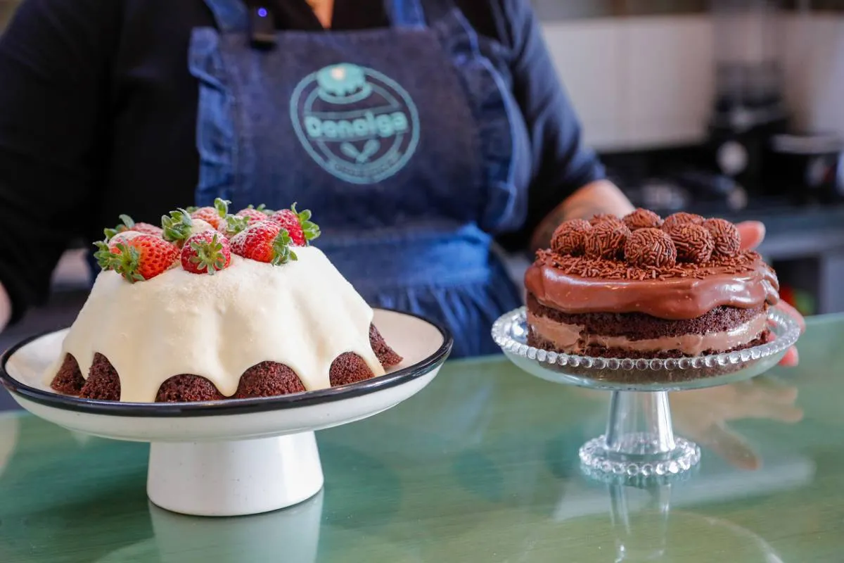 Imagem mostra uma confeiteira fazendo um belo e saboroso bolo.