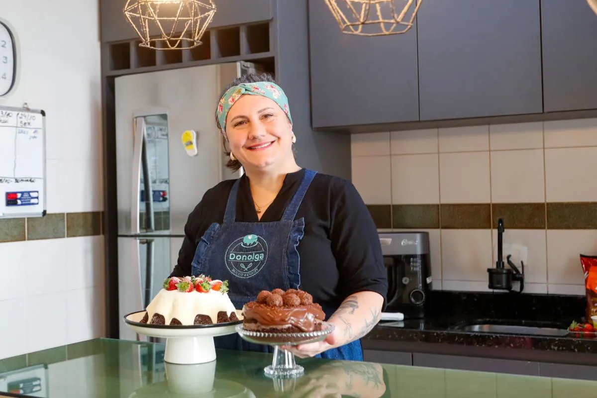 Imagem mostra uma confeiteira fazendo um belo e saboroso bolo.