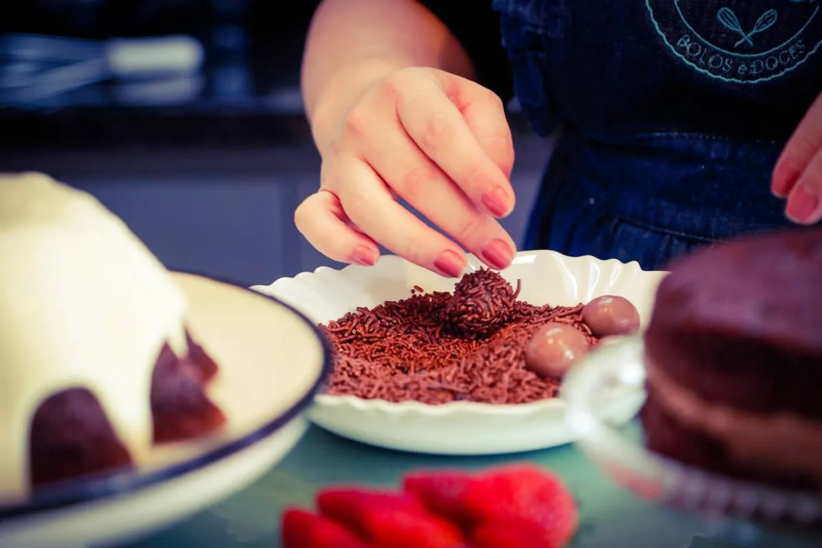 Imagem mostra uma confeiteira fazendo um belo e saboroso bolo.