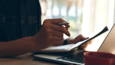 Imagem mostra uma pessoa na frente de um computador.