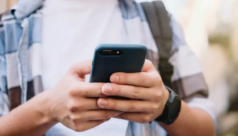 Imagem mostra homem segurando celular