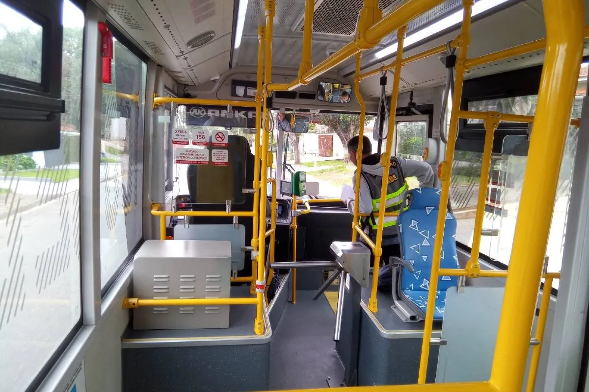 Imagem mostra um micro ônibus elétrico  de cor verde flagrado circulando pelas ruas de Curitiba em uma linha de transporte coletivo.