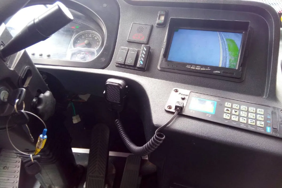 Imagem mostra um micro ônibus elétrico  de cor verde flagrado circulando pelas ruas de Curitiba em uma linha de transporte coletivo.