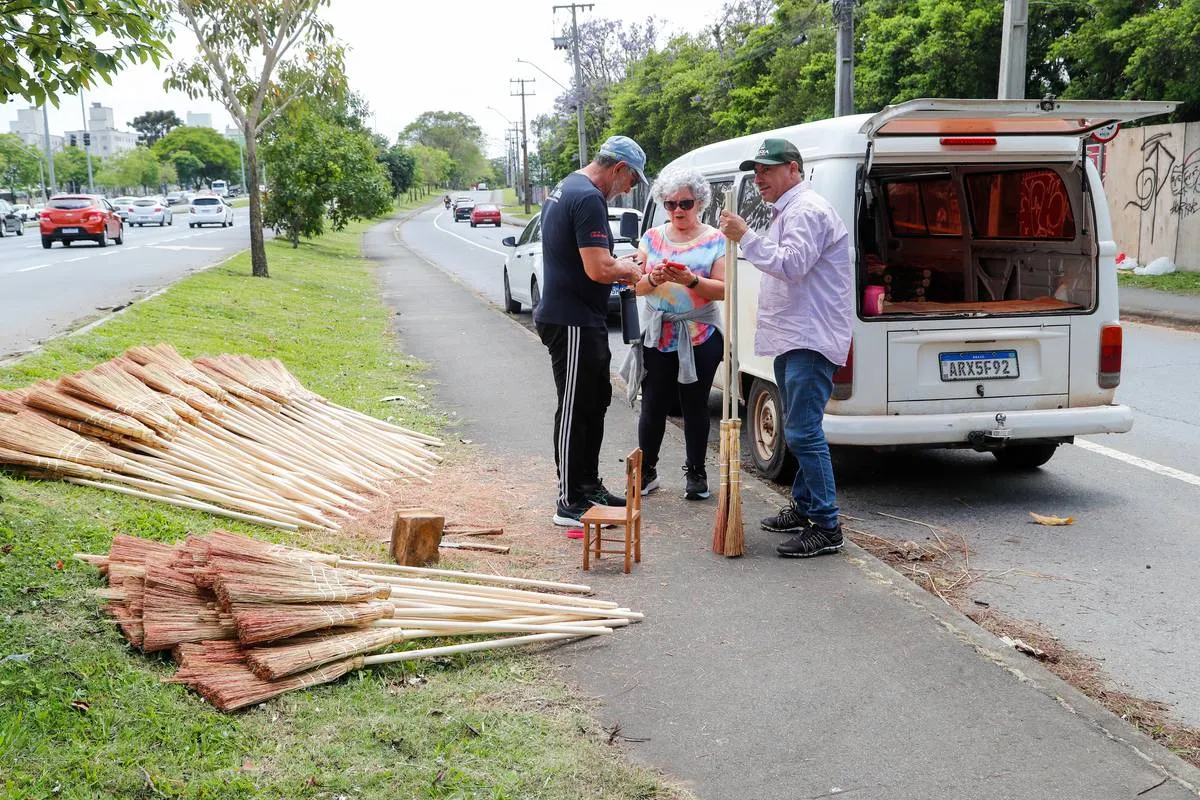 Imagem mostra um homem montando as tradicionais vassouras de palha em Curitiba. 
