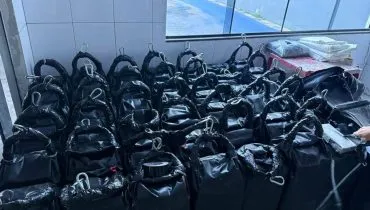 Imagem mostra galões pretos cheios de cocaína.