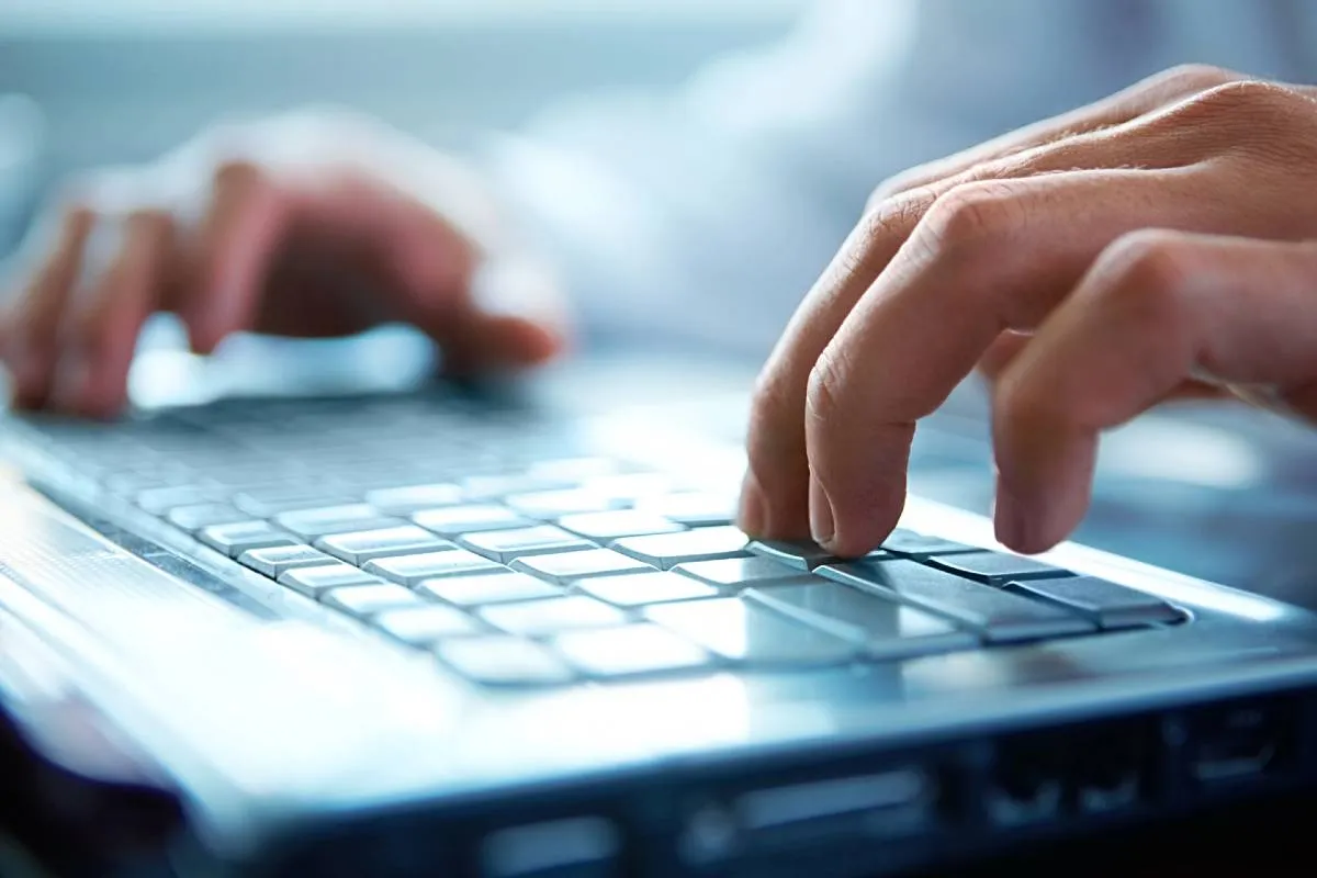 Imagem mostra uma pessoa digitando em um teclado.