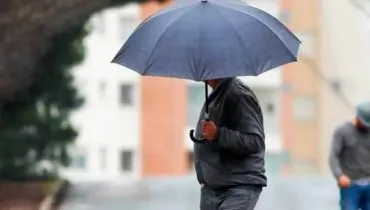 Imagem mostra uma pessoa com guarda chuva no meio de uma rua de Curitiba.