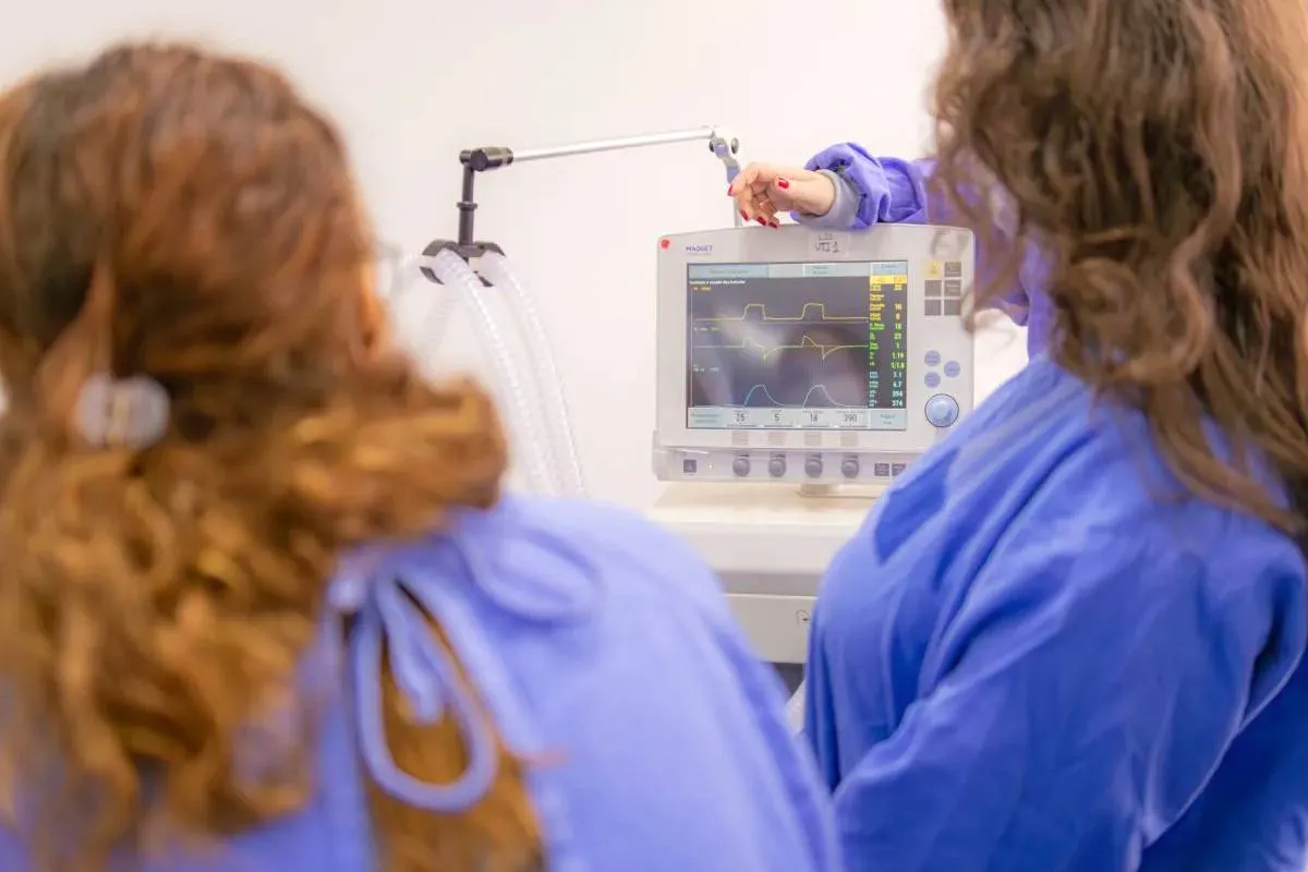 Imagem mostra duas pessoas trabalhando em um aparelho de imagem