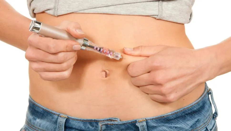 Imagem mostra uma mulher aplicando uma caneta emagrecedora.