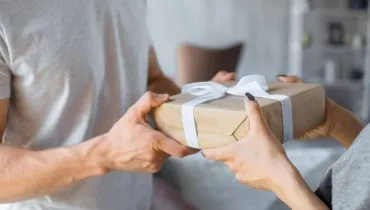 Imagem mostra uma pessoa dando um presente misterioso.