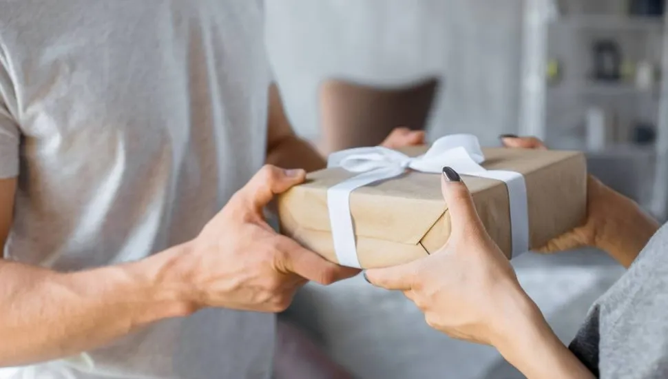 Imagem mostra uma pessoa dando um presente misterioso.