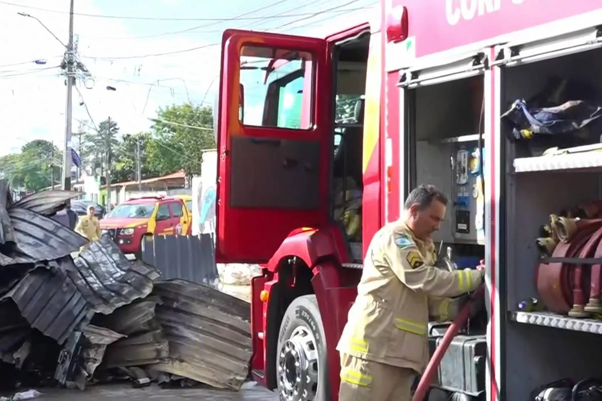 Imagem mostra um Bombeiro trabalhando em um caminhão dos Bombeiros.