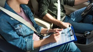 Imagem mostra uma instrutora e um homem em um caro.