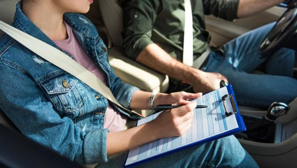 Imagem mostra uma instrutora e um homem em um caro.