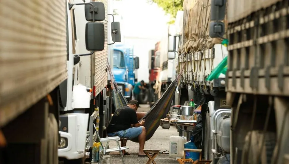 Imagem mostra caminhões estacionados.