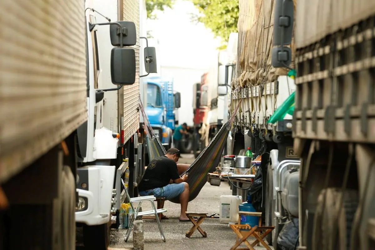 Imagem mostra caminhões estacionados.
