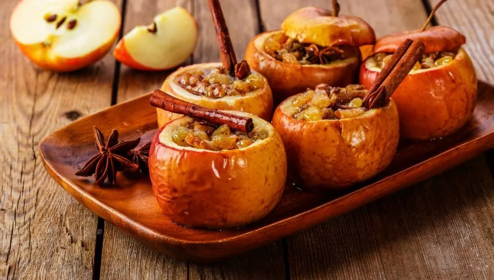 Imagem mostra uma maça assada na air fryer decorada com canela em pau