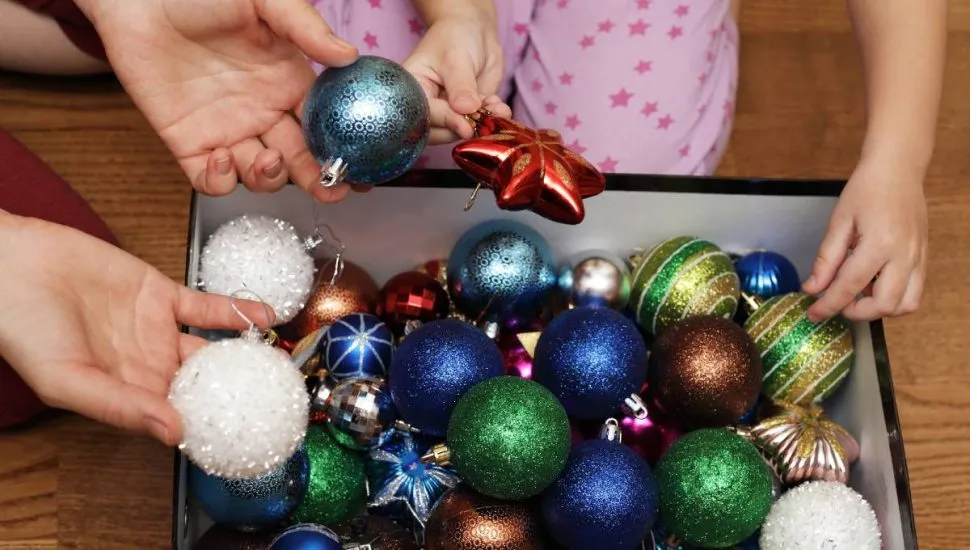 Imagem mostra uma pessoa guardando as decorações de Natal em uma caixa. Dia de Reis 2026: por que esta terça marca o fim do Natal e o dia certo de desmontar a árvore