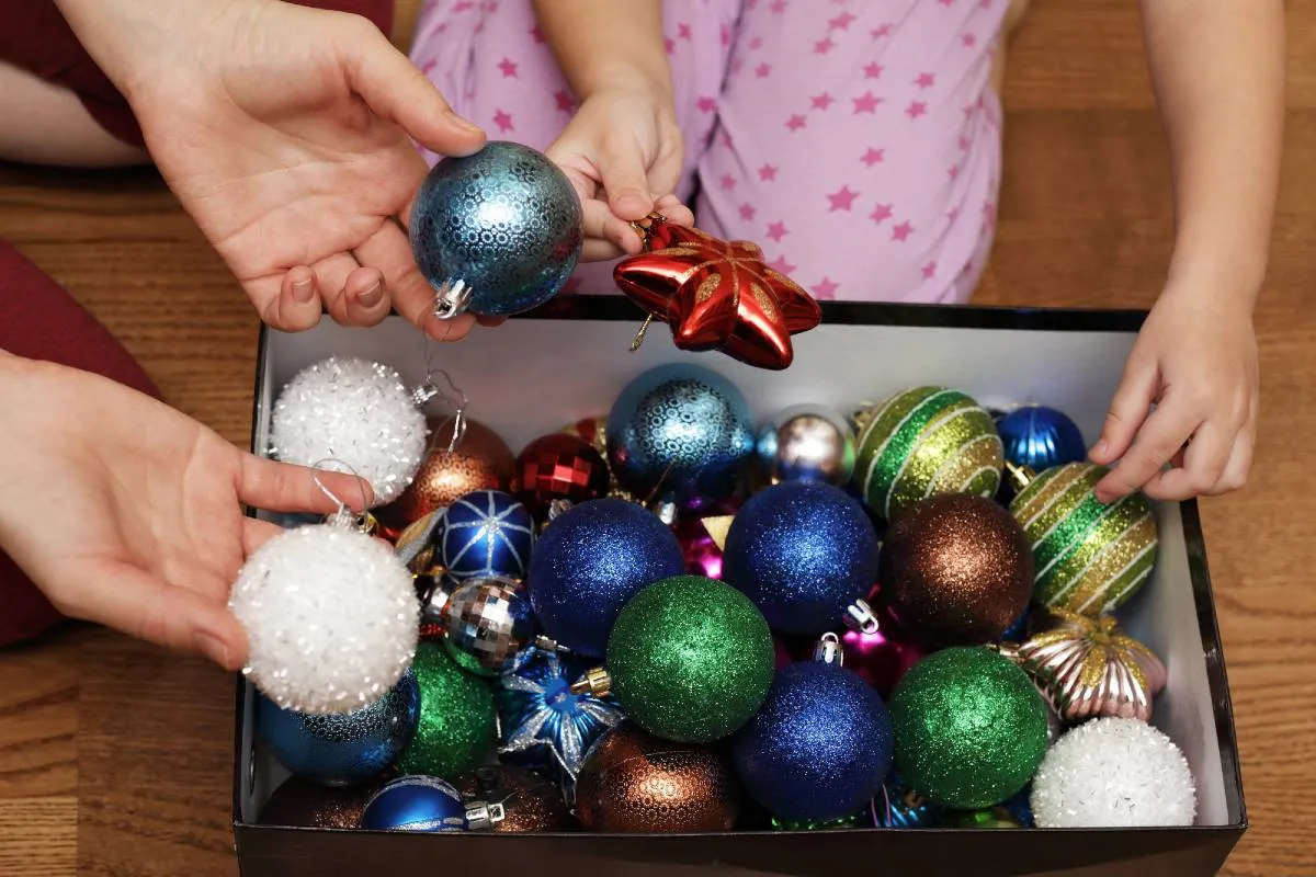 Imagem mostra uma pessoa guardando as decorações de Natal em uma caixa. Dia de Reis 2026: por que esta terça marca o fim do Natal e o dia certo de desmontar a árvore