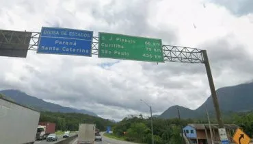 Imagem mostra uma placa bem na divisa entre Paraná e Santa Catarina.