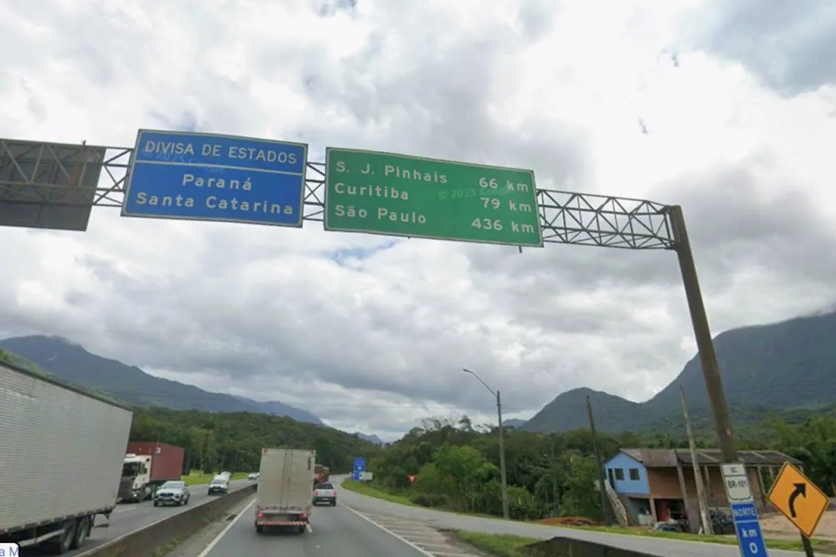 Imagem mostra uma placa bem na divisa entre Paraná e Santa Catarina.