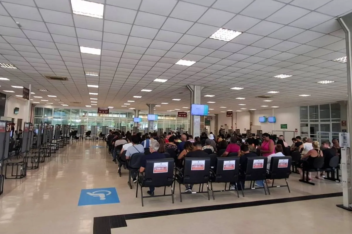 Imagem mostra a fila para atendimentos nos guichês do TRE-PR, no Parolin