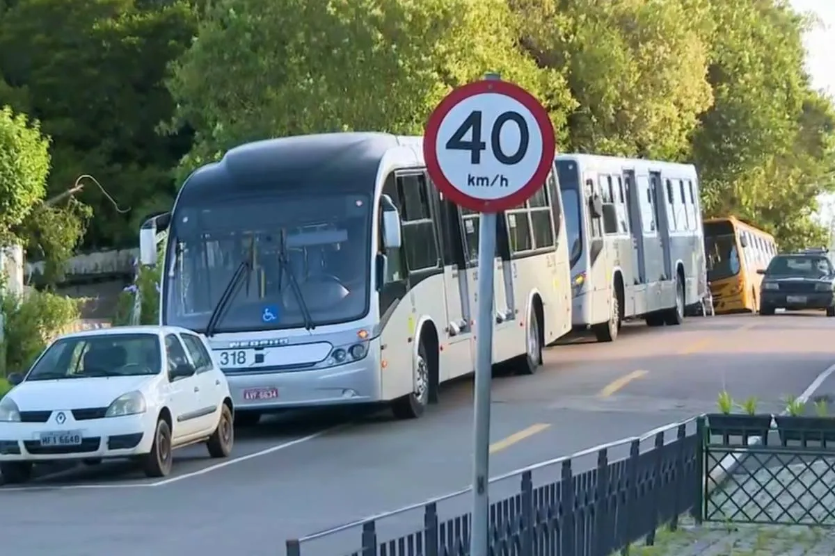 Imagem mostra ônibus parados em uma rua de Curitiba.
