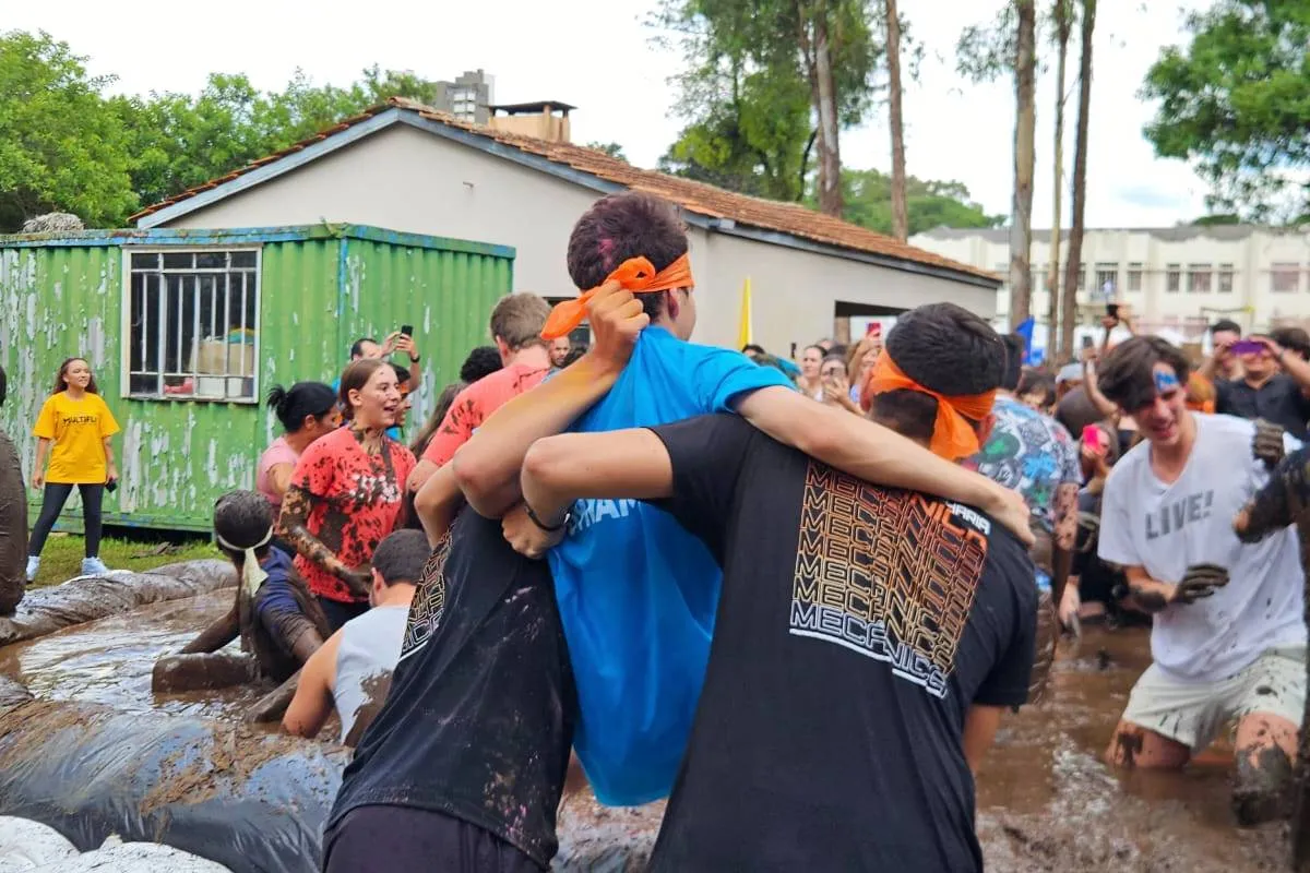 Imagem mostra a festa e o banho de lama com os aprovados no vestibular da UFPR 2026.