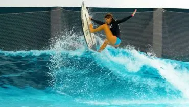 Imagem mostra mulher fazendo manobra em onda artificial do SurfCenter