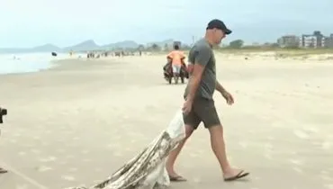 Imagem mostra um homem puxando um saco gigante utilizado para contenção da ressaca.
