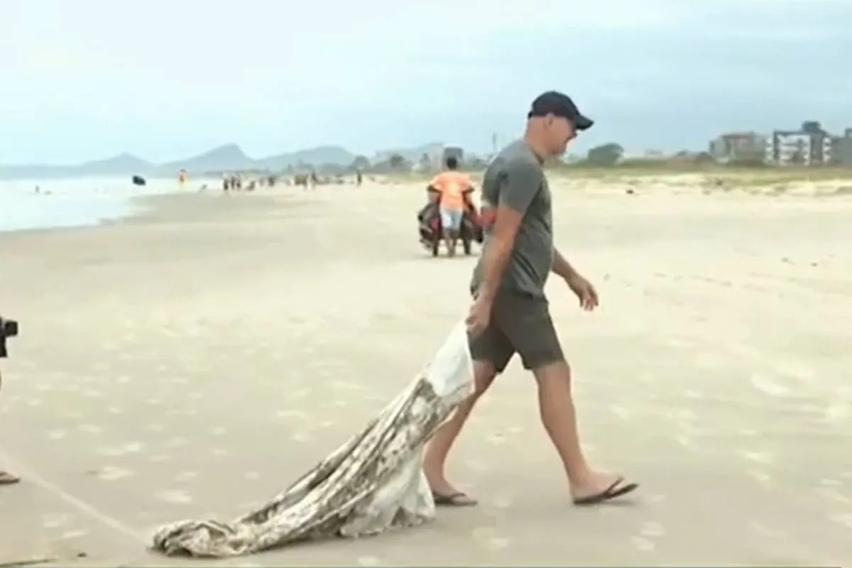 Imagem mostra um homem puxando um saco gigante utilizado para contenção da ressaca.