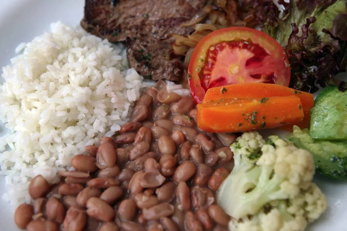 Imagem mostra um clássico prato feito com arroz, feijão, bife e salada.