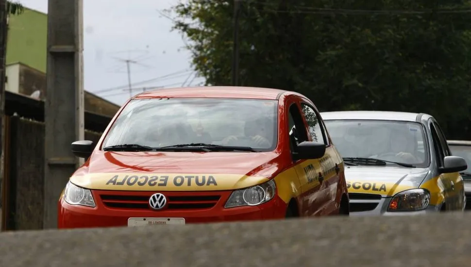 Imagem mostra dois carro de auto escola.