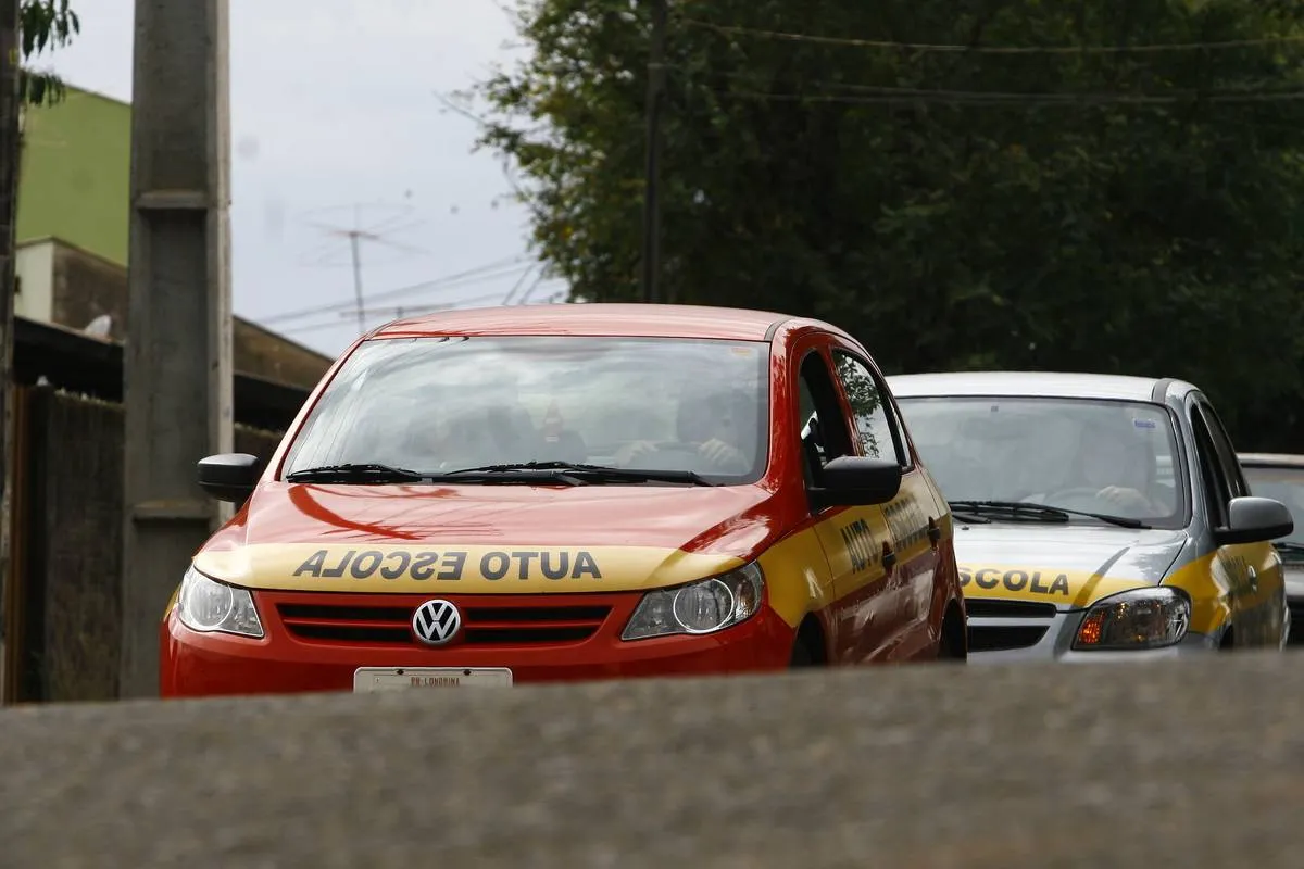 Imagem mostra dois carro de auto escola.